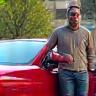 Ahmed S. stands beside his shiny car